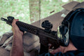 Shooter aiming a rifle at a target during defensive rifle training
