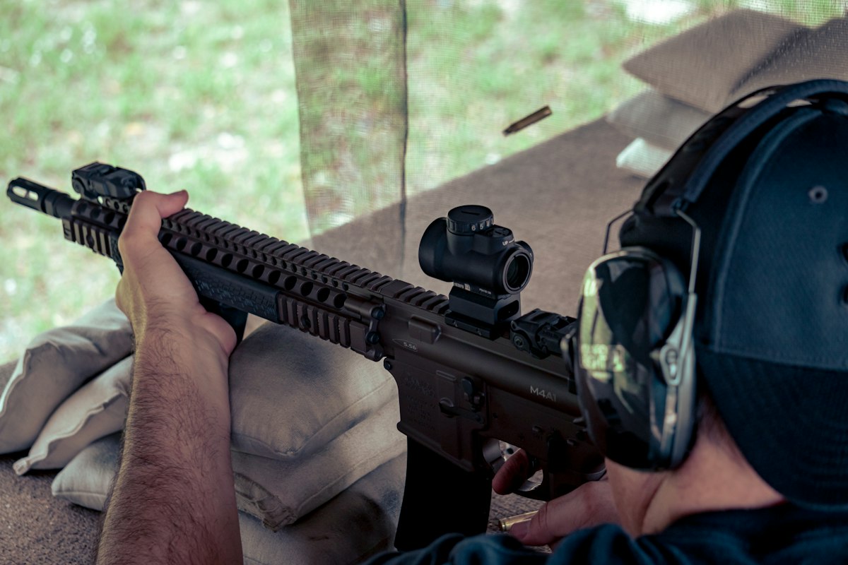 Shooter aiming a rifle at a target during defensive rifle training
